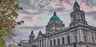 white and green concrete building under white clouds during daytime