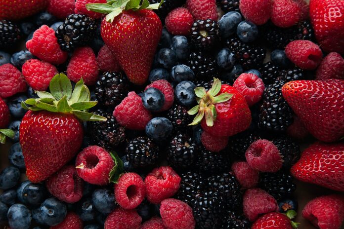strawberries and blueberries on white ceramic plate