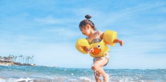 girl playing beside body of water during daytime