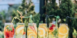 six clear glass mason jars filled with juice on black table