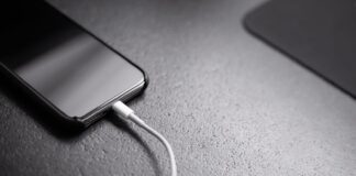 black smartphone with charger cord connected