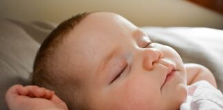 sleeping baby on gray cushion