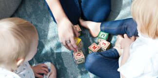 two toddler playing letter cubes