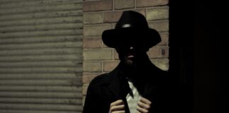 man wearing black fedora hat and black suit jacket