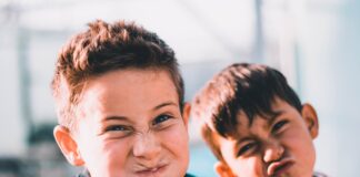 shallow focus photography of two boys doing wacky faces