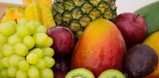 red apple fruit beside green apple and yellow fruit on brown woven basket