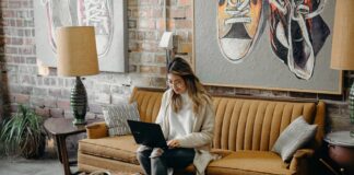 woman using laptop while sitting on chair