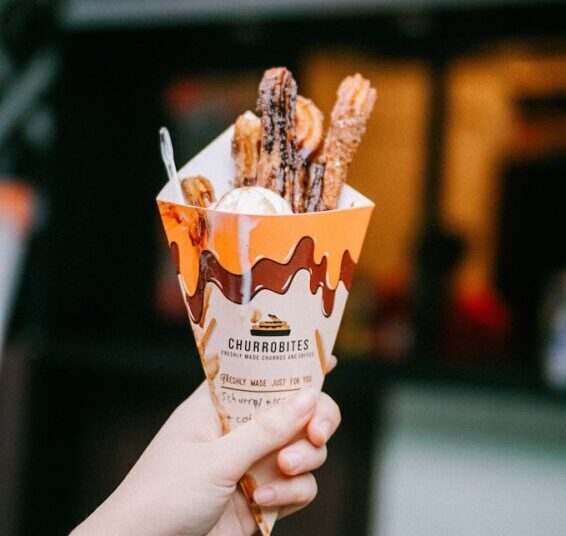 person holding white and brown ice cream cone