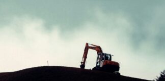 a bulldozer on top of a hill on a cloudy day