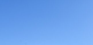 a flag on top of a mountain with mountains in the background