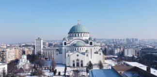 a large white building with a green dome