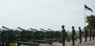 soldiers in green camouflage uniform standing on gray asphalt road during daytime