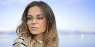 woman wearing black and white striped top and round eyeglasses