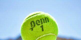 green tennis ball on hand