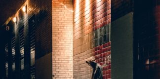 man learning on concrete wall