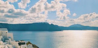 white and blue concrete building near body of water during daytime