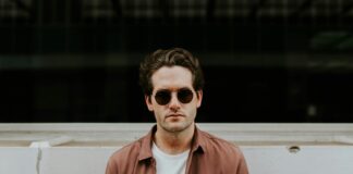 man standing in front of white concrete wall