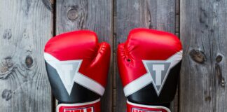 pair of red-and-black Title training gloves on grey wooden plank