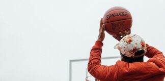 person holding basketball looking at basketball hoop system