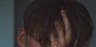 man covering face using right hand