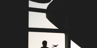 silhouette of man holding luggage inside airport
