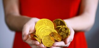 person holding gold-colored ching coins