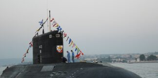 black ship on sea under gray sky during daytime
