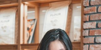 woman reading and sitting beside table inside room