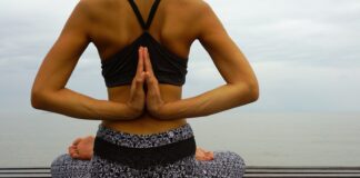 woman in black sports bra and black and white skirt sitting on white and black textile
