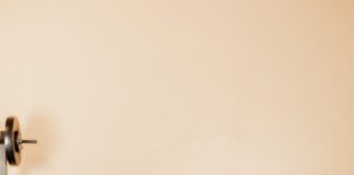 man in black tank top and black shorts holding black dumbbells