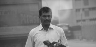 a black and white photo of a man holding a camera