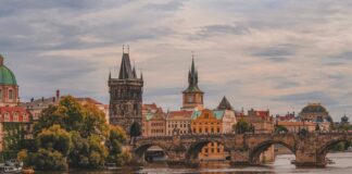 white and brown boat on river near brown concrete building during daytime