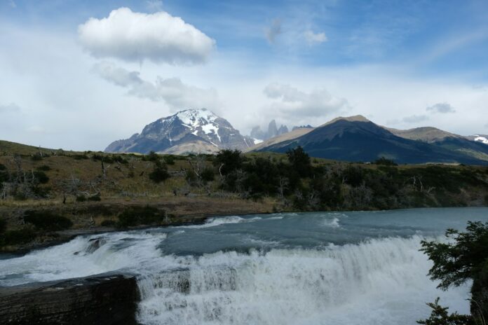 a waterfall with a mountain in the background