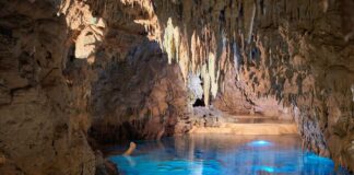 cave with calm body of water during daytime