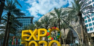 a sign that says expo expo in front of palm trees
