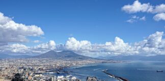 city buildings near body of water under blue and white cloudy sky during daytime