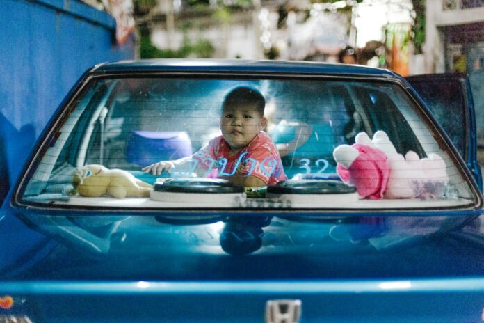 a small child sitting in the back of a blue car