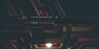 view of floating open book from stacked books in library