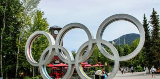 A statue of the olympic rings in a park