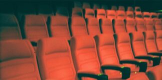 a row of empty red seats in a theater