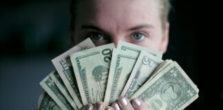 person holding fan of U.S. dollars banknote
