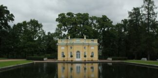 yellow concrete building near green trees and river during daytime