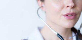 a woman in a white shirt holding a stethoscope