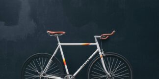 gray fixie bike leaning on black wall