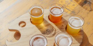 five poured drinking glasses on brown wooden tray
