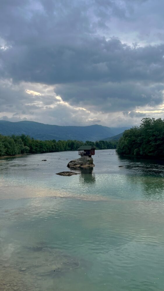 a body of water surrounded by trees and mountains