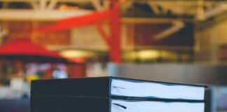 six black books on top of brown wooden table