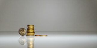 a stack of coins sitting on top of a reflective surface