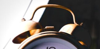 silver twin-bell alarm clock at 8:05