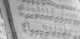 a close up of a piano keyboard with sheet music